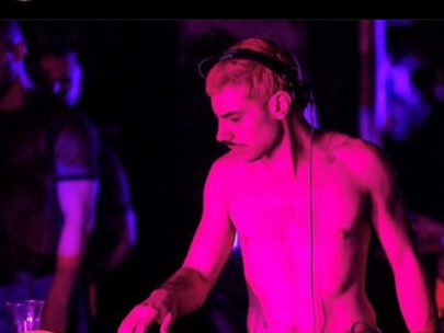 Tom Foolery bare-chested while spinning the decks