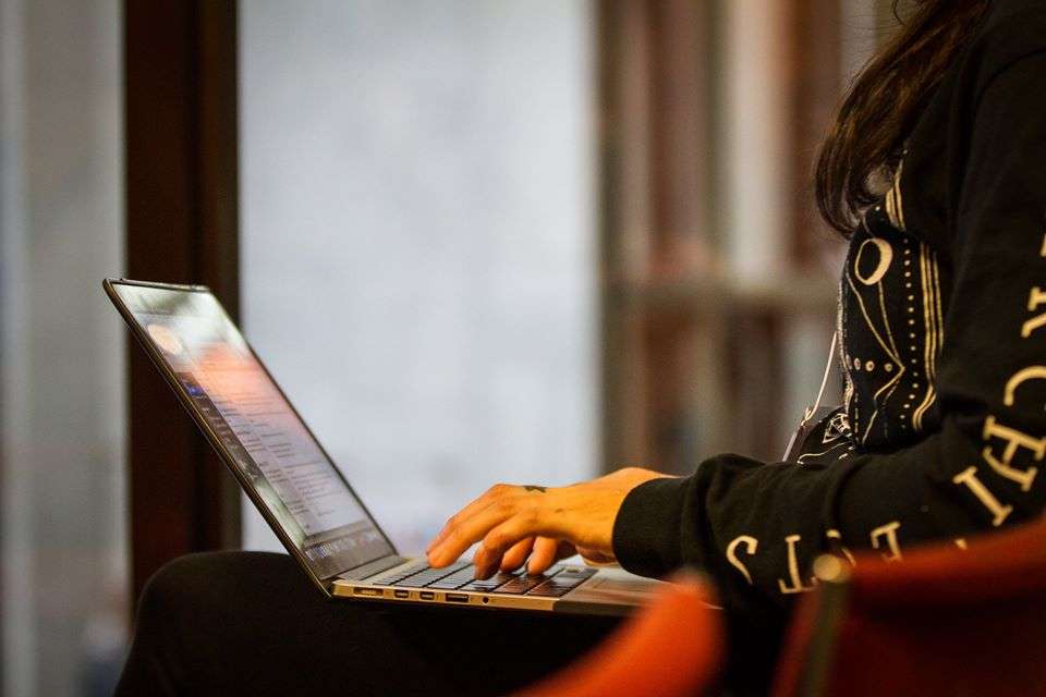 Person typing on a laptop. Only their arms and torso are visible.